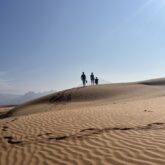 Groupe de randonneurs marchant sur des dunes de sable dans le désert d'Oman