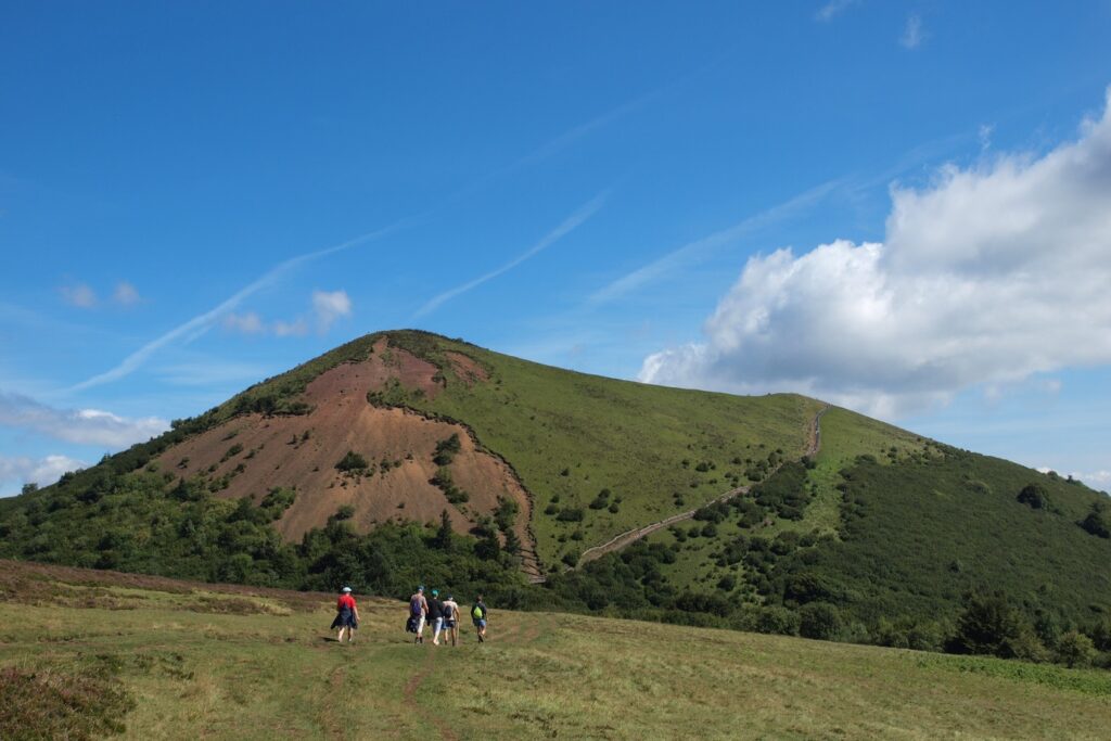 Paysage de montagne dans le massif central avec un groupe de randonneurs sur un sentier