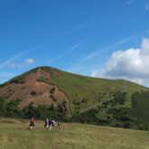 Paysage de montagne dans le massif central avec un groupe de randonneurs sur un sentier