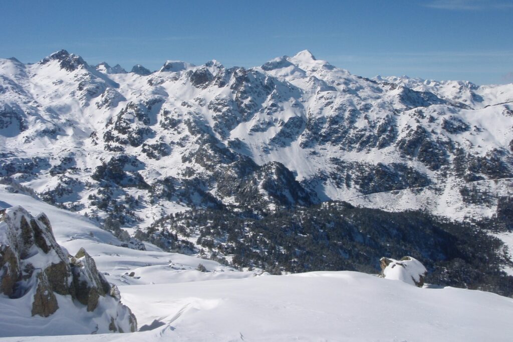 Paysage montagnard avec des sommets à l'arrière-plan et une pleine recouverte de neige