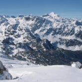 Paysage montagnard avec des sommets à l'arrière-plan et une pleine recouverte de neige