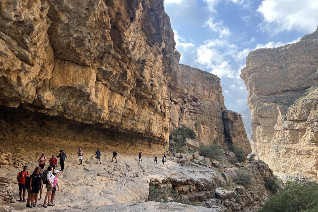 groupe de randonneurs avec leur guide sur un sentier de randonnée taillé dans la roche