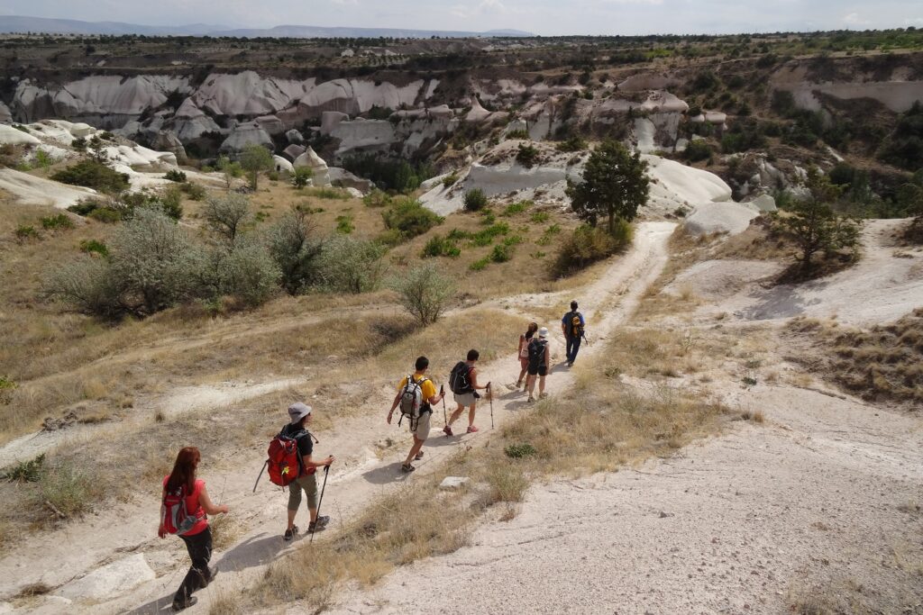 Groupe de randonneurs avec leur guide sur un sentier de randonnée encadré de paysage de pierre blanche en Turquie