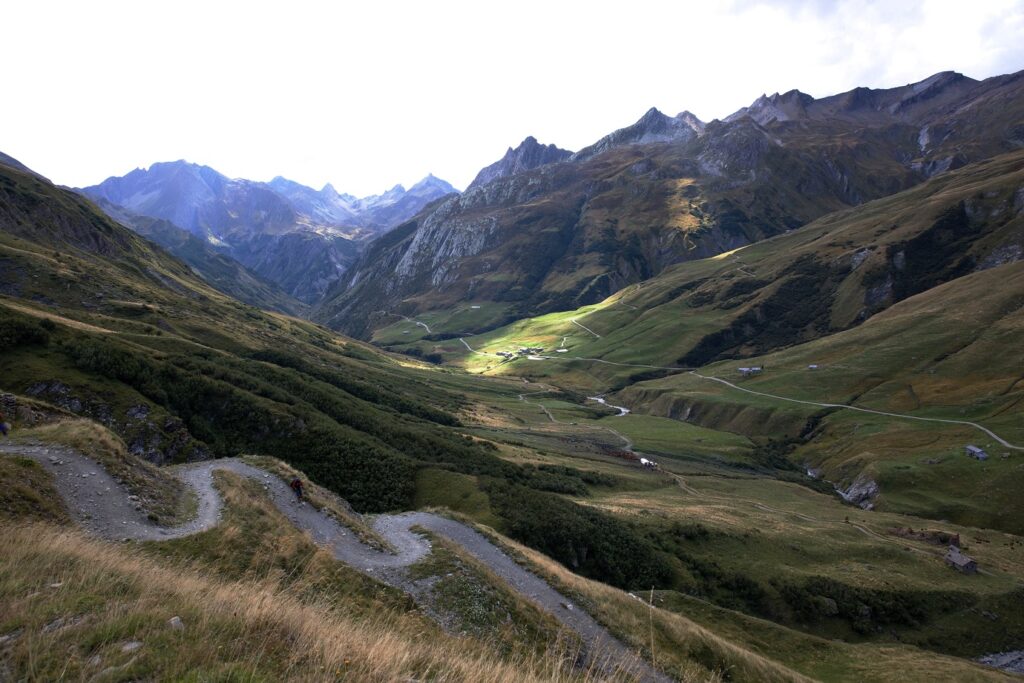 Paysage montagnard avec une route à flanc de montagne et des sommets en fond