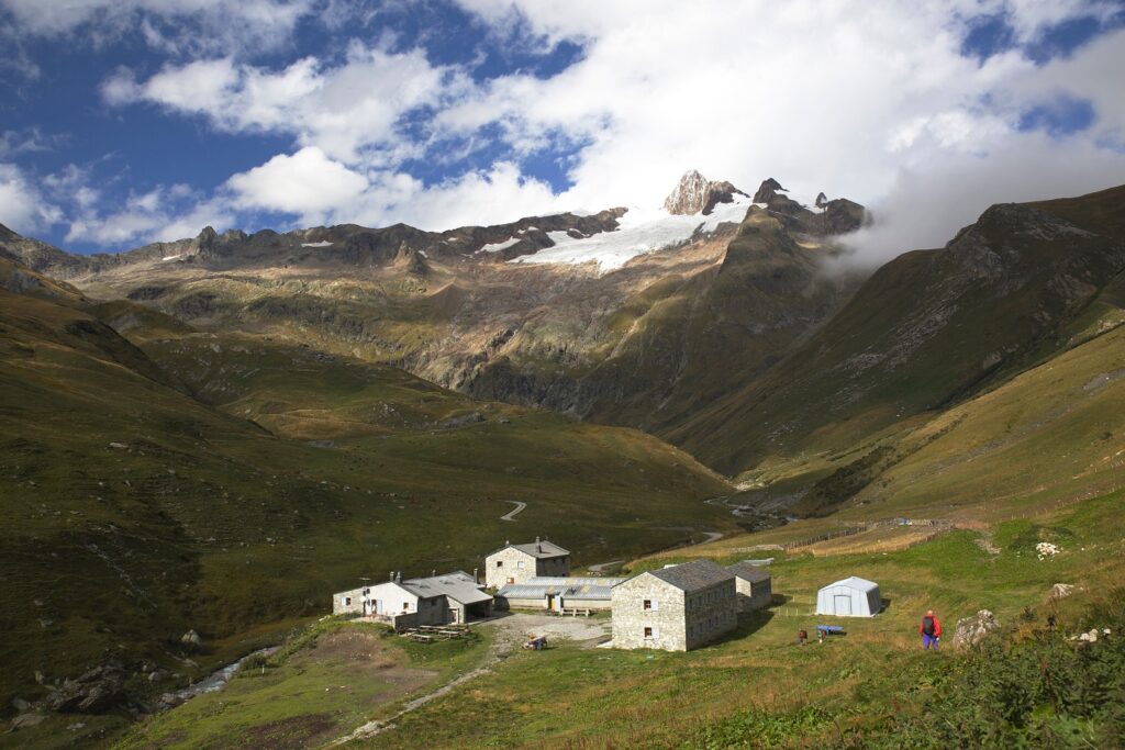 Paysage de montagne avec un groupement de maisons en contrebas et différents sommets en contrebas