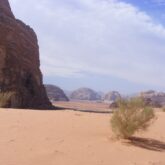 Paysage désertique en Jordanie, avec sur la gauche un relief et du sable, paysage caractéristique de la Jordanie et du désert du Wadi Rum