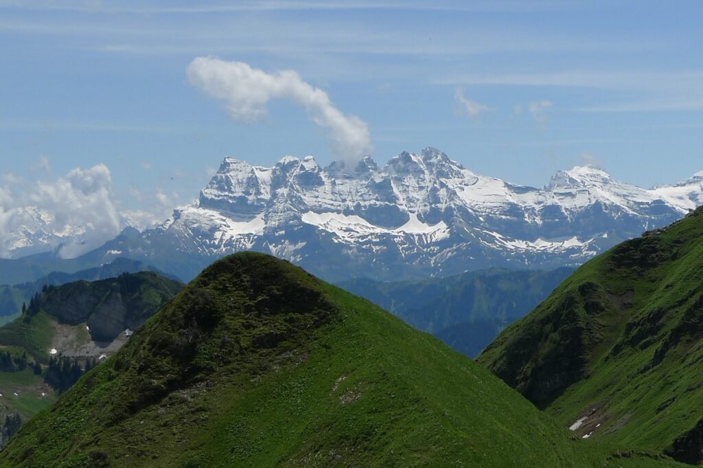 Paysage de montagne dans le massif du Chablais avec en fond des sommets enneigés et au premier plan des sommets couverts de végétation