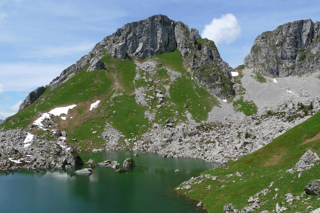 Paysage observé lors d'un séjour accompagné dans le massif du Chablais, avec au premier plan un lac de montagne surplombé par des sommets