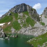 Paysage observé lors d'un séjour accompagné dans le massif du Chablais, avec au premier plan un lac de montagne surplombé par des sommets