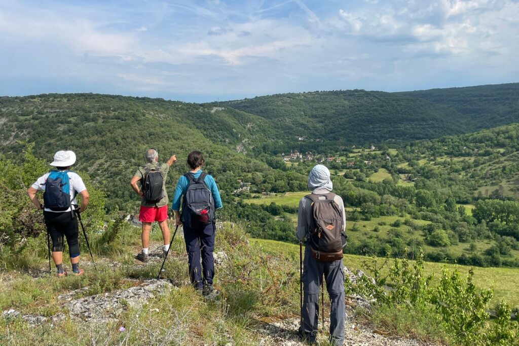 Groupe de randonneurs sur un sentier de randonnée avec leur guide en train d'observer la vallée