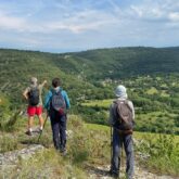 Groupe de randonneurs sur un sentier de randonnée avec leur guide en train d'observer la vallée