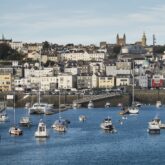 Vue sur le port d'une des îles avec de nombreux bateaux accostés et la ville en arrière-plan
