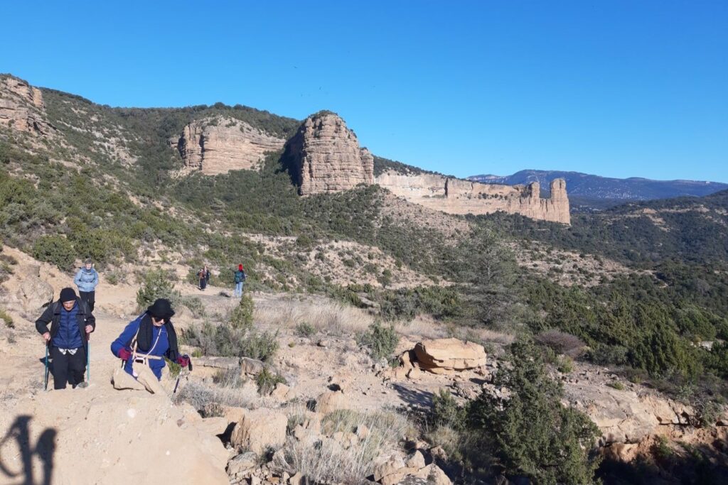 Groupe en plein milieu de la Sierra de Guara avec derrière une grande falaise