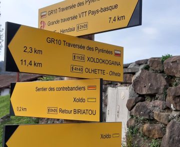 Photo d'un panneau de balisage de randonnée, qui indique plusieurs directions