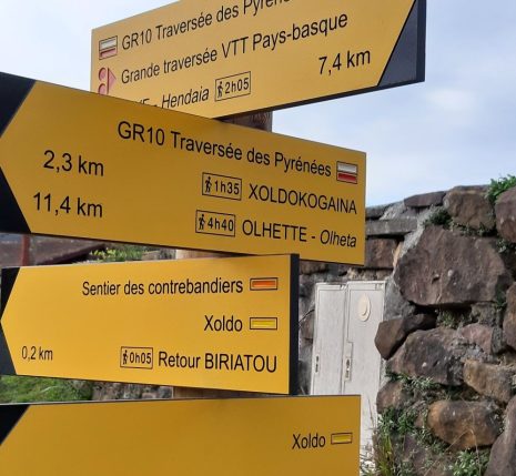 Photo d'un panneau de balisage de randonnée, qui indique plusieurs directions