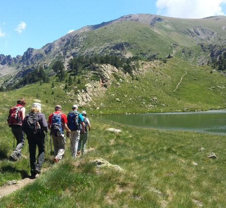 Groupe de randonneurs sur un sentier se dirigeant vers un lac de montagne entre Cauterets et Luchon