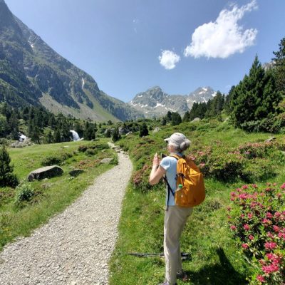 Randonneuse sur un chemin, prenant des photo du paysage dans la vallée de Cauterets