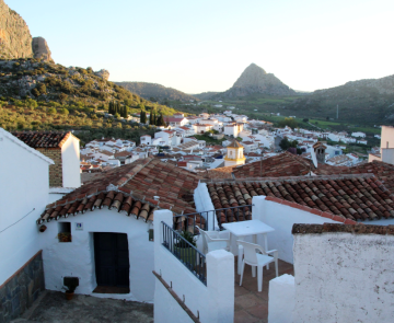 Paysage andalou au coucher du soleil avec des maisons blanches au premier plan et des sommets à l'arrière