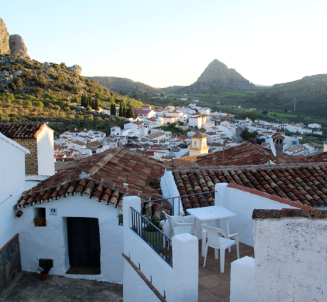 Paysage andalou au coucher du soleil avec des maisons blanches au premier plan et des sommets à l'arrière