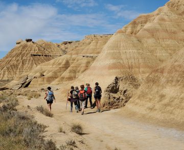 Groupe de randonneurs sur un paysage des bardenas caractéristique du paysage sec de la zone