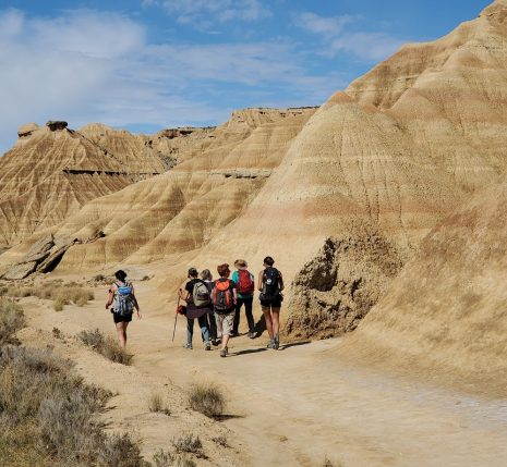 Groupe de randonneurs sur un paysage des bardenas caractéristique du paysage sec de la zone