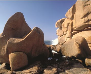 cote-de-granit-rose-randonnee Paysage côtier sur la côte de granit rose en Bretagne avec de gros rochers et en fond l'océan