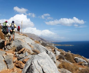 Groupe de randonneurs sur un sentier de montagne avec la mer en contrebas en Crète