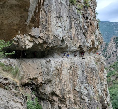 Groupe de randonneurs sur un sentier à flanc de montagne ancré dans la montagne