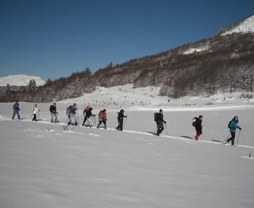groupe de randonneurs en raquette qui font leur trace dans la neige en suivant leur guide, au cours d'un séjour raquette dans la vallée d'Ax