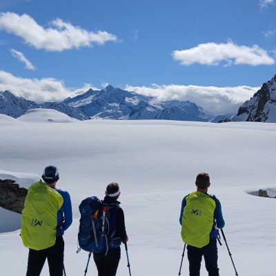 Groupe de randonneurs en raquettes avec leur guide face aux montagnes enneigées du massif du Néouvielle.