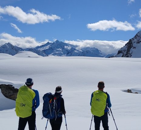 Groupe de randonneurs en raquettes avec leur guide face aux montagnes enneigées du massif du Néouvielle.
