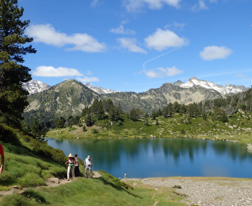 Groupe de randonneurs au bord d'un lac de montagne sur un sentier