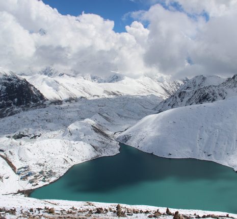 Paysage montagnard au Népal avec un lac bleu au milieu des montagnes enneigées