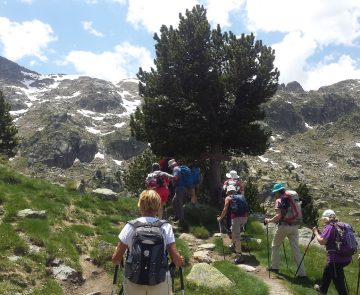 Groupe de randonneurs sur un sentier de randonnée aux abords d'un lac de montagne dans les Encantats
