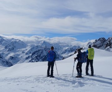 Groupe de randonneurs face à la vue lors d'une randonnée en raquettes avec leur guide dans les hautes Pyrénées entre le Néouvielle et Cauterets