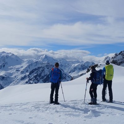 Groupe de randonneurs face à la vue lors d'une randonnée en raquettes avec leur guide dans les hautes Pyrénées entre le Néouvielle et Cauterets