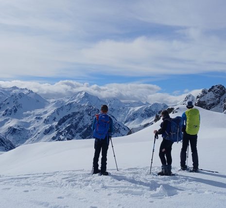 Groupe de randonneurs face à la vue lors d'une randonnée en raquettes avec leur guide dans les hautes Pyrénées entre le Néouvielle et Cauterets