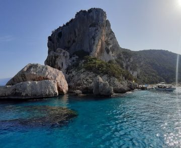 Paysage de Sardaigne avec de l'eau turquoise qui encadre des rochers qui sortent de l'eau