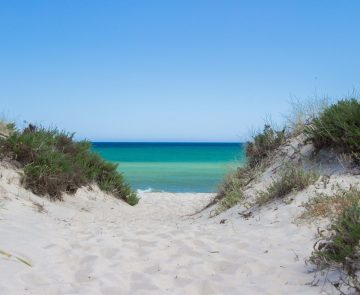 Paysage paradisiaque de bord de mer avec un sable blanc et une eau turquoise au Portugal
