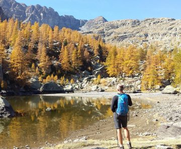 rando-mercantour-etoile Randonneur face à un lac dans le Mercantour, avec face à lui une forêt surplombée par des montagnes