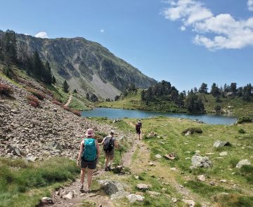 Groupe de randonneurs sur un sentier qui se dirigent vers un lac de montagne