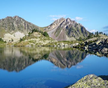 Paysage de montagne avec, au premier plan, un lac et des sommets dans le fond.