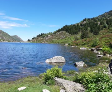 Lac de montagne avec paysage ensoleillé encadré de sommets