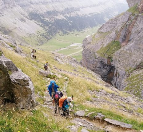 Groupes de randonneurs sur un sentier avec leur guide sur la haute randonnée pyrénéenne entre le Vignemale et les Posets