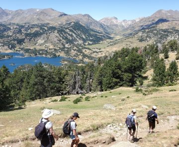 groupe de randonneurs sur un sentier avec leur guide en train de descendre un pan de la montagne