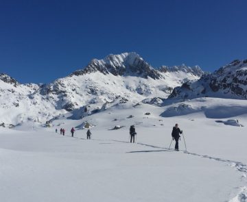 Paysage hivernal dans les encantats, avec un groupe de randonneurs sur un sentier avec leur guide lors d'une randonnée en raquettes