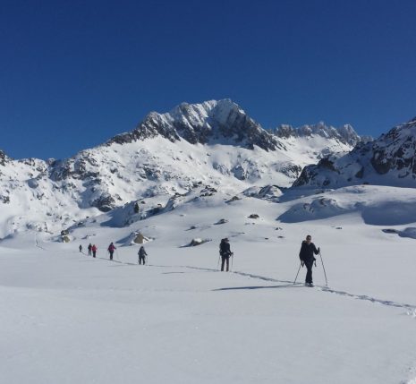 Paysage hivernal dans les encantats, avec un groupe de randonneurs sur un sentier avec leur guide lors d'une randonnée en raquettes