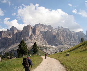 Randonneurs sur un sentier de montagnes dans les dolomites, avec face à lui un sommet