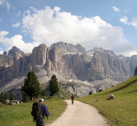 Randonneurs sur un sentier de montagnes dans les dolomites, avec face à lui un sommet