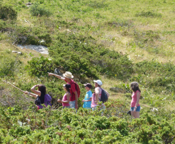 Groupe de famille avec leur guide qui font de la randonnée en montagne dans les Pyrénées